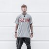 Portrait of a fashionable tattooed young man wearing streetwear against a minimalist background.